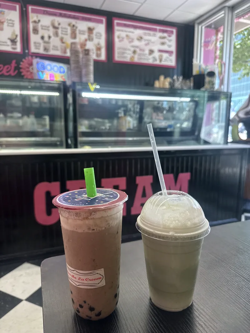 A chocolate bubble tea with tapioca pearls and a matcha drink with foam on the black counter